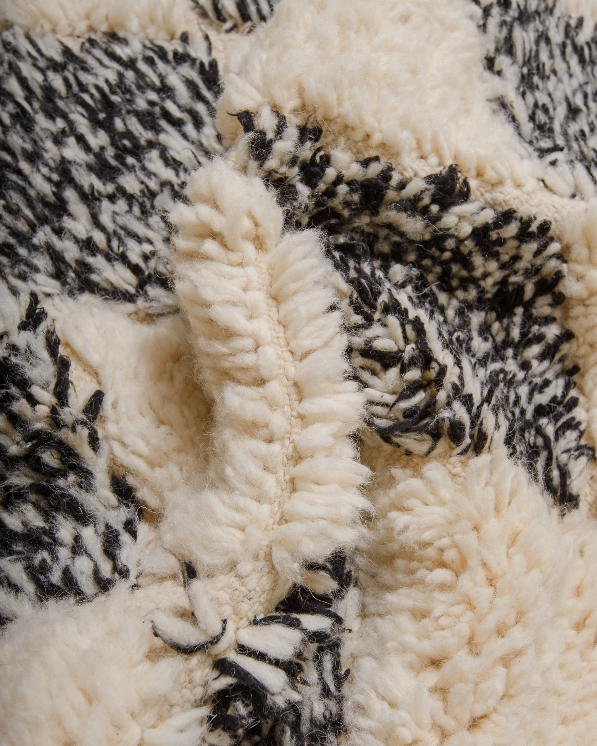 Detail of wool berber rug showing depth of pile and different coloured wool used.